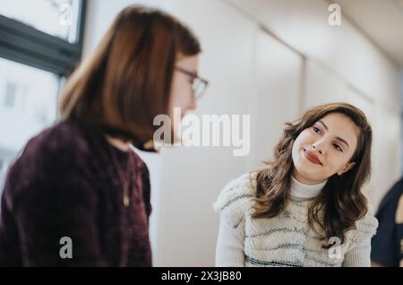 Cheerful business team brainstorming in a modern kitchen, discussing ideas for a successful start-up while enjoying coffee and tea. Stock Photo