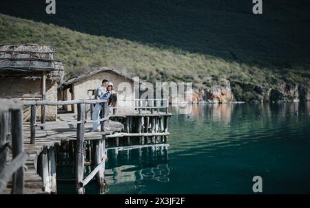 Couple enjoying a serene moment on a rustic dock during a lovely vacation Stock Photo