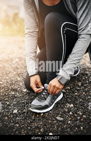 Person, hands and shoelace with running or workout for fitness, health and wellbeing in outdoor. Above, sneakers and committed on exercise or jog in Stock Photo