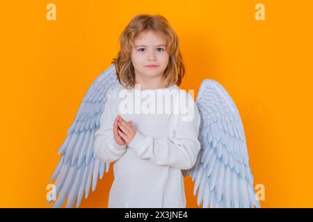 Angel prayer kids. Valentines day. Little cupid angel child with wings. Studio portrait of angelic kid Stock Photo