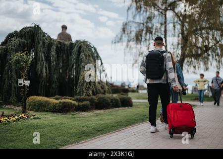 Young friends traveling together, exploring a quaint city park on a sunny day Stock Photo