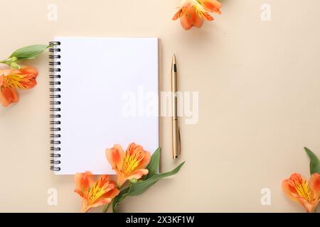 Guest list. Notebook, pen and beautiful flowers on beige background, flat lay. Space for text Stock Photo