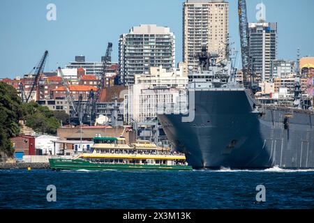 Sydney ferry passes Garden island naval base of the Royal Australian Navy, Potts Point apartment towers behind,Sydney,NSW,Australia Stock Photo