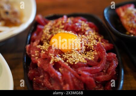 Beef tartare is a traditional Korean dish made by seasoning finely chopped beef without cooking it at all. Stock Photo