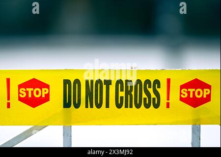Stop. Do Not cross! Warning yellow tape on fence at crime place Stock Photo