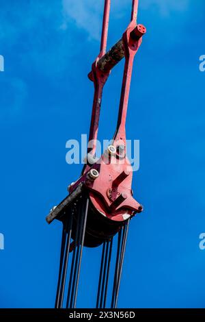 Close-up of a winch on a crane against a blue sky Stock Photo