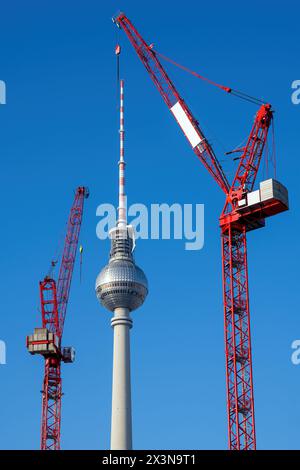 The famous Television Tower of Berlin with two red tower cranes Stock Photo