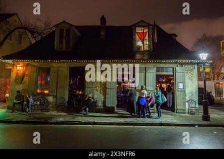French Quarter, New Orleans, Louisiana.  Night Scene at Jean Lafitte's Blacksmith Shop Bar, Bourbon Street.  Built between 1722-32. Stock Photo