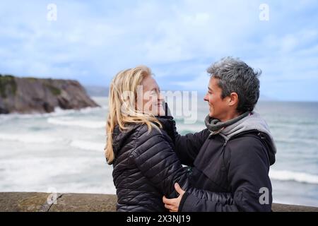 A women family hugging on a beach. Scene is warm and affectionate Stock Photo