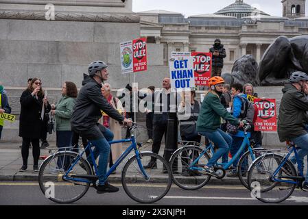 London, UK. 27th Apr, 2024. Cyclists are passing by the protesters on the Trafalgar Square in London, UK. ULEZ stands for Ultra Low Emission Zone. It has been introduced in April 2019 to help generate a cleaner air in London. The expansion happened on the end of August 2023. Now, the ULEZ covers the majority of land within M25. Protesters blame for that Sadiq Khan, the Mayor of London and they do not believe in air pollution. Credit: SOPA Images Limited/Alamy Live News Stock Photo