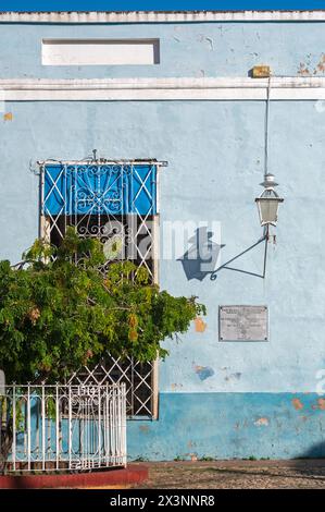 An old metal lamp casting a shadow on a blue painted wall in the backstreets of the Old Town, Trinidad, Cuba. Stock Photo