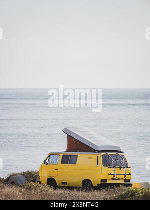Yellow vintage camper van with pop-up roof parked by the sea Stock ...