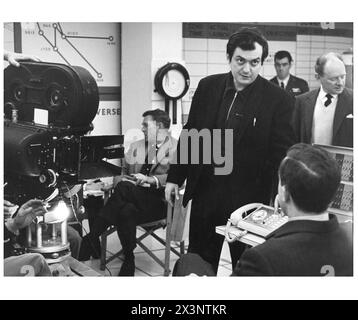 Director STANLEY KUBRICK talks to PETER SELLERS in costume for his role as Group Captain Lionel Mandrake on the set of DR. STRANGELOVE or : How I Learned to Stop Worrying and Love the Bomb 1964.Sitting behind him is STERLING HAYDEN who played Brigadier General Jack D. Ripper. Book PETER GEORGE Screenplay STANLEY KUBRICK, TERRY SOUTHERN and PETER GEORGE Production Design KEN ADAM Hawk Films / Columbia Pictures Stock Photo