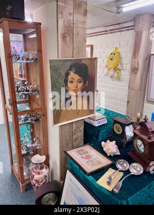 60s kitsch painting nina in an antique centre with watch cabinet and clocks shell vase Stock Photo
