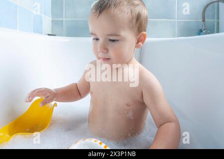 two-year-old playing in the bathtub Stock Photo