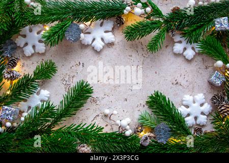 Christmas tree spruce for frame with light, gifts, dry cones and decor on the wood background in sunny winter day. Copy space. Top view. Stock Photo
