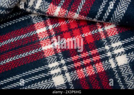 Blue, white, red cage texture fabric. Winter cashmere scarf. Textile warm dark knitted cloth background. Stock Photo