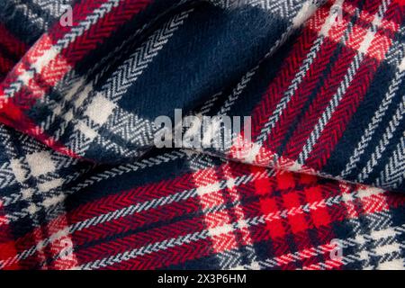 Blue, white, red cage texture fabric. Winter cashmere scarf. Textile warm dark knitted cloth background. Stock Photo