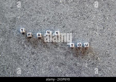 Thank you exclamation word on the stone background. Stock Photo