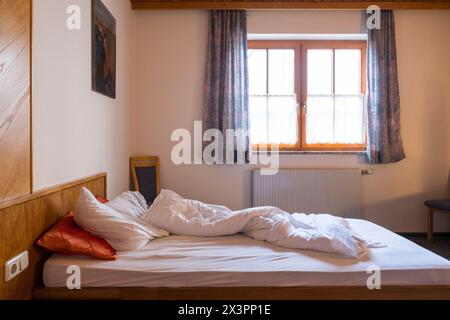 Single bed unmade,  in a hotel room. Stock Photo