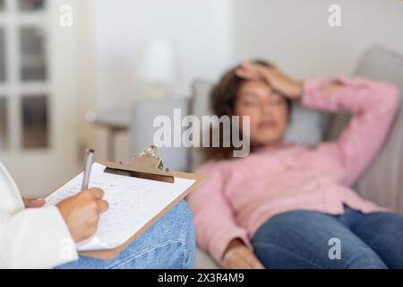 Unrecognizable therapist listening to woman client, taking notes Stock Photo