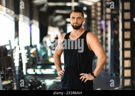 Man Standing in Gym With Hands on Hips Stock Photo