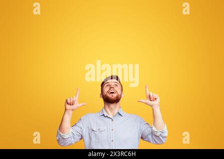 Man Raises Hands in Front of Yellow Background Stock Photo