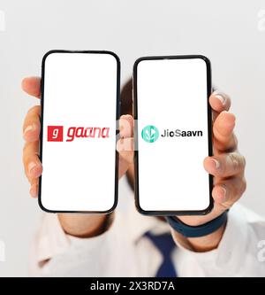 Gaana Vs JioSaavan music listening app comparison to find out best, shown on two different smartphone screens editorial backdrop Stock Photo