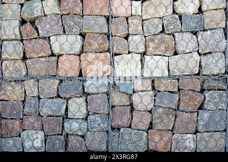 Engineering structure made of stones behind metal wire netting to strengthen the dune bank near sea. Stock Photo