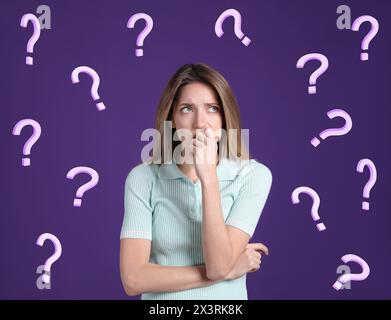 Amnesia. Confused young woman and question marks on purple background Stock Photo