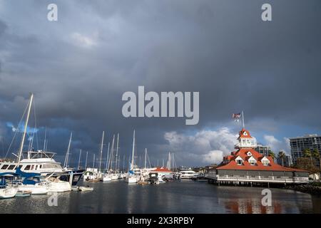 San Diego, CA. April 5, 2024. Glorietta Bay marina in the evening against storm sky, featuring mostly blue and white boats Stock Photo