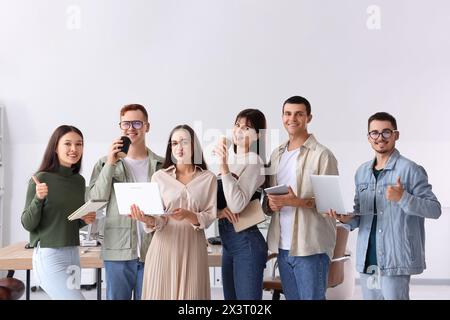 Team of young programmers with gadgets in office Stock Photo