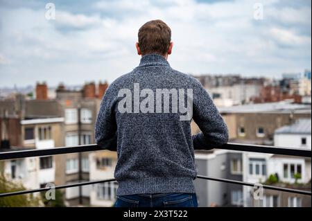Portrait of a 45 yo man, turning his back on a terrace, Brussels Belgium. Model released. Stock Photo