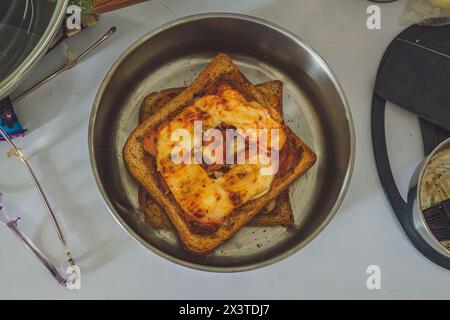 a delicious homemade toast pizza, a quick and easy meal that can be made with pantry staples. The dish features slices of bread topped with melted che Stock Photo
