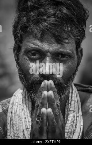 Portrait of a Indian Sheppard with his hands makes a gesture of namaste with joined hands in front. Man with hands clasped in front of mouth, glancing Stock Photo