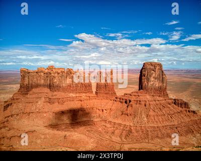 A massive rock formation stands prominently in the desert landscape of Monument Valley near the Utah and Arizona border. Stock Photo