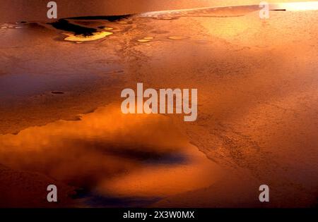 Red sunset reflection on ice covered lake Stock Photo
