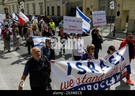 People walk along the streets of Warsaw with Israeli and Polish flags and placards saying 'Israel you are not alone» and «Israel we stand with you» during the annual March of Life event held in connection with the celebration of Holocaust Remembrance Day (Yom HaShoah). Hundreds of people participated in The March of Life, which takes place annually in Warsaw in connection with the celebration of Holocaust Remembrance Day (Yom HaShoah). Participants start near the Sigismund's Column in the heart of the Old Town in Warsaw and walk down the street to the Museum of the History of Polish Jews, Pol Stock Photo