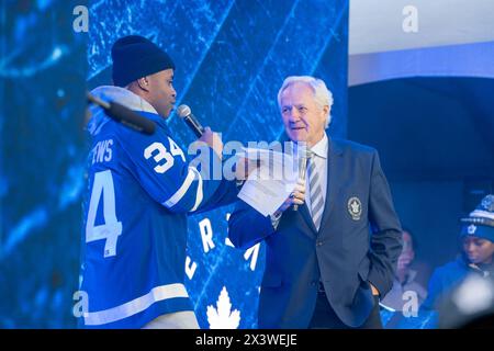 Former Leaf captain and hockey legend Darryl Sittler on stage at Maple Leaf Square outside Scotibank Arena, before Round 1, Game 4 playoff game of Toronto Maple Leafs vs Boston Bruins playoff game During Toronto Maple Leafs playoff games, Maple Leaf Square transforms into a sea of blue and white, echoing with the chants of passionate fans eagerly rallying behind their team's quest for victory. The electric atmosphere radiates anticipation and excitement, creating unforgettable memories for both die-hard supporters and casual observers alike. Stock Photo