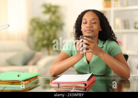 Black student relaxing drinking coffee or tea at home Stock Photo