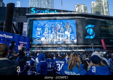April 24, 2024, Toronto, Ontario, Canada: Fans gather at Maple Leaf Square outside Scotibank Arena, watching Round 1, Game 4 playoff game of Toronto Maple Leafs vs Boston Bruins playoff game on a giant screen. During Toronto Maple Leafs playoff games, Maple Leaf Square transforms into a sea of blue and white, echoing with the chants of passionate fans eagerly rallying behind their team's quest for victory. The electric atmosphere radiates anticipation and excitement, creating unforgettable memories for both die-hard supporters and casual observers alike. (Credit Image: © Shawn Goldberg/SOPA Im Stock Photo