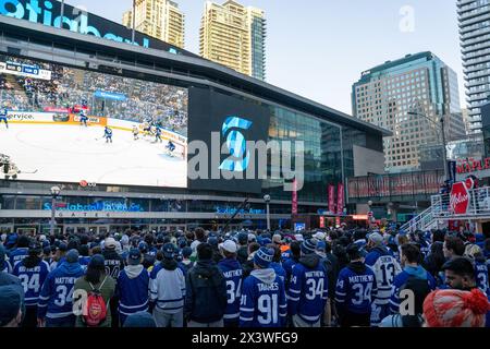 April 24, 2024, Toronto, Ontario, Canada: Fans gather at Maple Leaf Square outside Scotibank Arena, watching Round 1, Game 4 playoff game of Toronto Maple Leafs vs Boston Bruins playoff game on a giant screen. During Toronto Maple Leafs playoff games, Maple Leaf Square transforms into a sea of blue and white, echoing with the chants of passionate fans eagerly rallying behind their team's quest for victory. The electric atmosphere radiates anticipation and excitement, creating unforgettable memories for both die-hard supporters and casual observers alike. (Credit Image: © Shawn Goldberg/SOPA Im Stock Photo