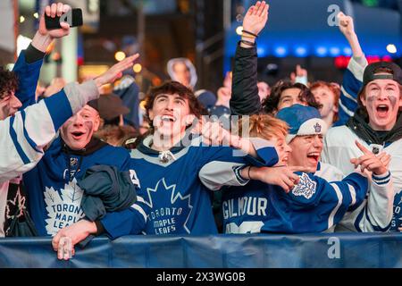 April 24, 2024, Toronto, Ontario, Canada: Fans watching the game on a giant screen react as the Toronto Maple Leafs score a goal against the Boston Bruins during Round 1, Game 4 at Maple Leaf Square outside Scotiabank Arena. During Toronto Maple Leafs playoff games, Maple Leaf Square transforms into a sea of blue and white, echoing with the chants of passionate fans eagerly rallying behind their team's quest for victory. The electric atmosphere radiates anticipation and excitement, creating unforgettable memories for both die-hard supporters and casual observers alike. (Credit Image: © Shawn G Stock Photo