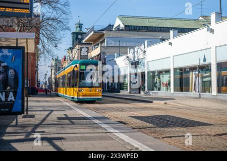 Tram on main street Drottningatan in the city center of Norrköping. The yellow trams are iconic for Norrköping. Stock Photo