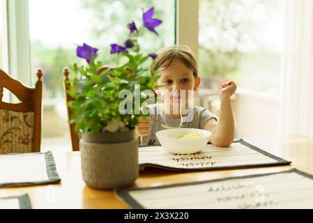 Cute little girl having breakfast in the morning at home. Healthy eating concept. Stock Photo