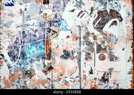 Texture of torn poster paper on a billboard as grunge background and design element Stock Photo