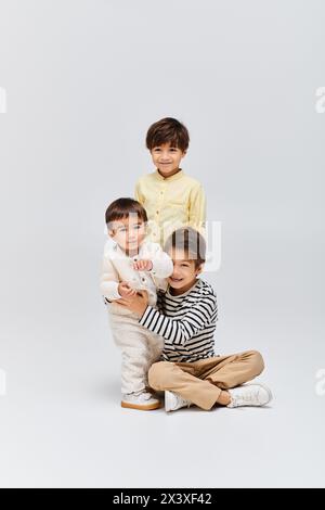 A diverse group of asian children posing together in a studio setting on a grey background. Stock Photo