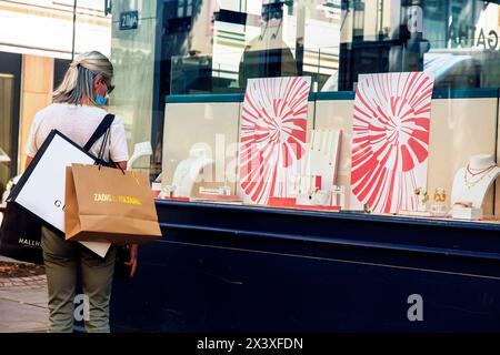 Deconfinement, Masked woman in front of a shop Stock Photo