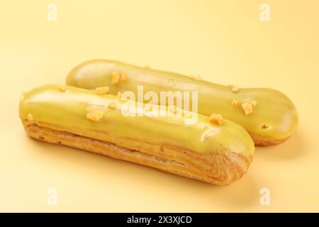 Delicious eclairs covered with glaze on yellow background Stock Photo