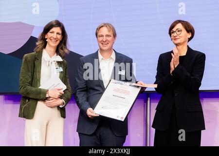 29 April 2024, Berlin: Andre Szymkowiak (M) from Thusneldastrasse Gymnasium in Cologne-Deutz is awarded first prize in the 'Exemplary School Management' category by Bettina Stark-Watzinger (FDP, r), Federal Minister of Education and Research, and Alexandra Heraeus (l), Chairwoman of the Board of the Heraeus Education Foundation, at the 'German Teachers' Award - Innovative Teaching' 2023 ceremony. The competition is sponsored by the German Philological Association and the Heraeus Education Foundation. Ten teachers, three school administrators and five teaching teams from twelve federal states w Stock Photo